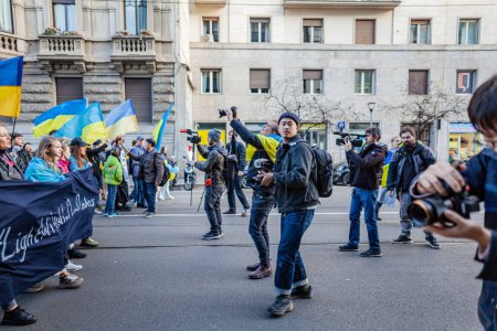Photo for MILAN, ITALY - FEBRUARY 25, 2023: One year after Russia-Ukraine war, 1st anniversary. Group of photojournalists documenting the street demonstration. - Royalty Free Image