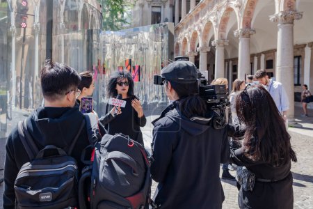 Photo for MILAN, ITALY-17 APRIL 2023: Interviews with journalists during the Fuorisalone event in the State University courtyard during the designweek and Salone del Mobile in Milan - Royalty Free Image