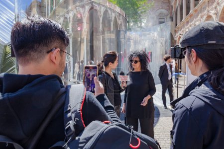 Photo for MILAN, ITALY-17 APRIL 2023: Interviews with journalists during the Fuorisalone event in the State University courtyard during the designweek and Salone del Mobile in Milan - Royalty Free Image