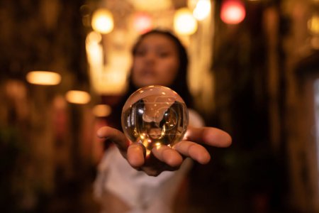 Téléchargez les photos : Asiatique femme tenant une boule de cristal dans la rue la nuit - en image libre de droit