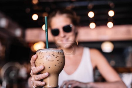 Foto de Mujer sosteniendo un vaso de café helado en una cafetería durante el verano - Imagen libre de derechos