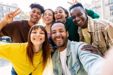 Feliz grupo joven de mejores amigos multirraciales divirtiéndose juntos al aire libre. Millennial diversas personas disfrutando del tiempo juntos tomando retrato de selfie en la calle de la ciudad