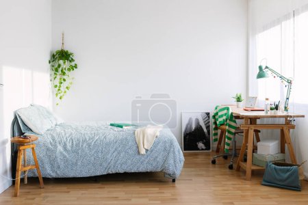 Foto de Cozy interior teenage girl room with bed, desk, laptop, photo and adolescence clothes - Imagen libre de derechos
