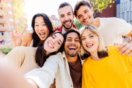 Photo for Happy group of diverse millennial friends taking selfie portrait together using mobile phone app. Multi ethnic teenage people having fun in city street. Friendship and youth lifestyle concept - Royalty Free Image