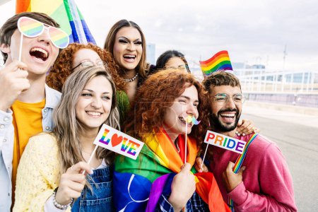 Joyeux groupe de jeunes célébrant ensemble le festival gay pride day. Amis adultes homosexuels millénaires profitant de la célébration sur l'égalité des droits et la liberté
