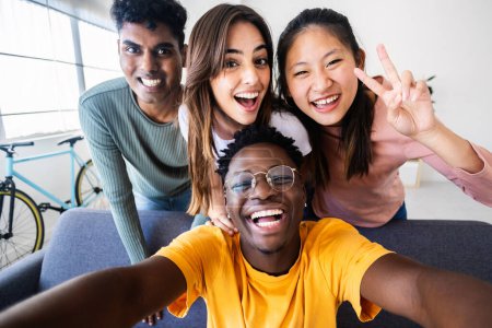 Photo for Young group of happy friends having fun at home taking selfie portrait. Youth community and friendship concept with boys and girls enjoying home party. - Royalty Free Image