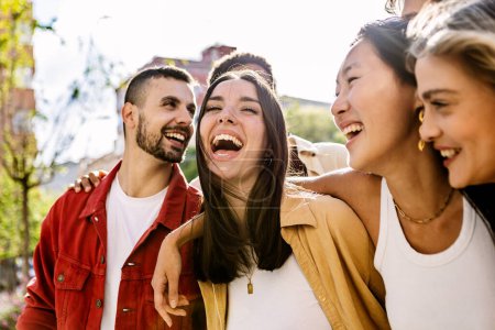 Photo for Diverse group of young friends having fun together outdoors in summer. Millennial student people laughing walking in city street enjoying day off. Youth community and friendship concept. - Royalty Free Image