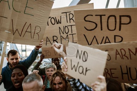 Aktivistengruppe marschiert für den Weltfrieden. Diverse Demonstranten mit Transparenten und Plakaten protestieren gegen Krieg und Gewalt. Kein Konzept zur Manifestation von Kriegsprotesten.