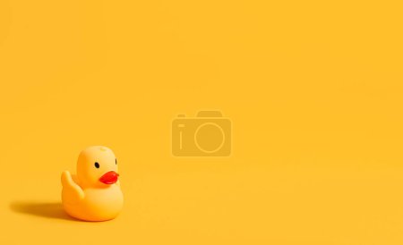 Téléchargez les photos : Canard en caoutchouc pour nager sur fond jaune. Jouet pour enfants. Bannière. Espace de copie. - en image libre de droit