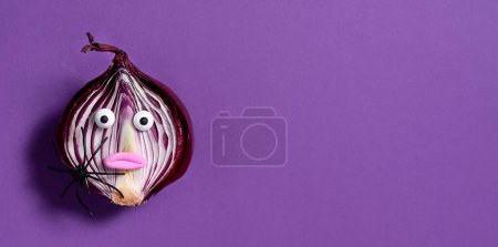 Téléchargez les photos : Fond d'Halloween. Oignon effrayant sur fond violet. La nourriture d'Halloween. Bannière. - en image libre de droit