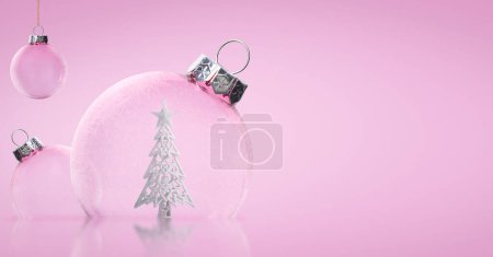 Pink Christmas transparent balls with a Christmas tree inside on a pink background. Christmas background. Banner. Copy space