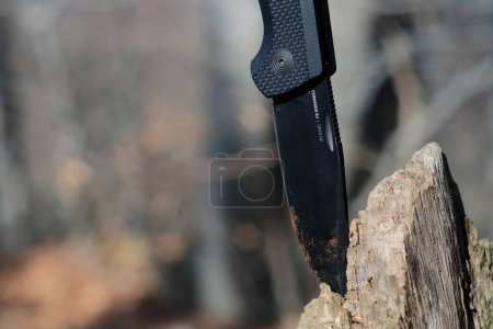 LVIV, UKRAINE - 27. Februar 2024: SOG Terminus schwarzes Messer im Wald auf Holzgrund.