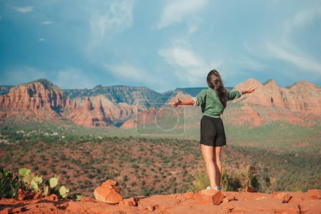 Young hiker woman on trail at Cathedral Rock in Sedona, Arizona. View from Scenic Cathedral Rock in Sedona with blue sky in Arizona