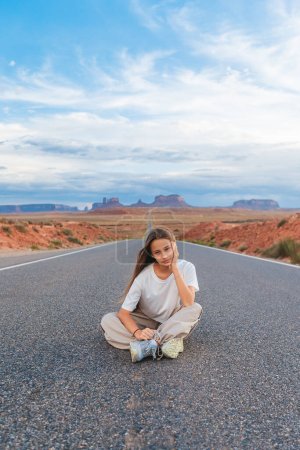 Photo for Happy girl raised her hands on the famous road to Monument Valley in Utah. Amazing view of the Monument valley. - Royalty Free Image