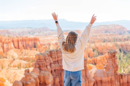 Foto de Vista posterior de la chica en Bryce Canyon disfrutando de la vista en el hermoso paisaje natural con hoodoos, pináculos y agujas formaciones rocosas en Utah. - Imagen libre de derechos
