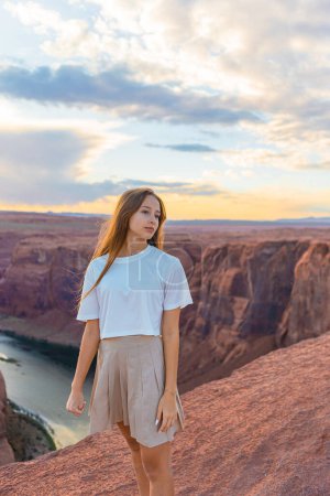 Photo for Happy girl at the famous Horseshoe Bend in Page Canyon with stunning views of the Colorado River, Arizona. Adventure and tourism concept. - Royalty Free Image