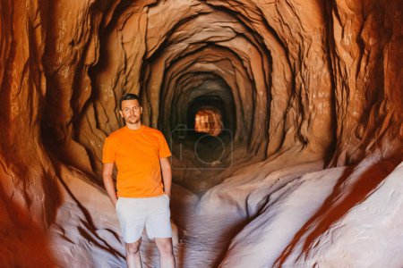 Photo for Young man hike on popular trail Belly of the Dragon Tunnel Cave in Kanab - Royalty Free Image