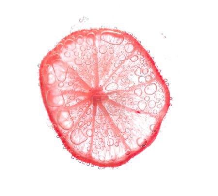 Foto de Jugosas rodajas de lima con burbujas bajo el agua aisladas sobre fondo blanco. Patrón rodajas de limón rojo fondo texturizado. - Imagen libre de derechos