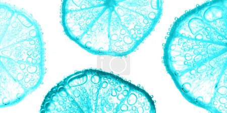 Foto de Jugosas rodajas de limón con burbujas bajo el agua aisladas sobre fondo blanco. Fondo texturizado patrón de rodajas de limón azul claro. - Imagen libre de derechos