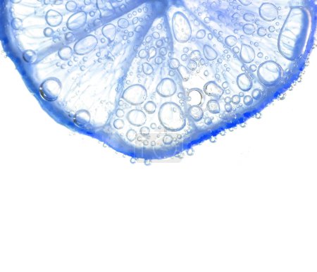 Foto de Jugosas rodajas de lima con burbujas bajo el agua aisladas sobre fondo blanco. Azul limón rebanadas patrón texturizado fondo. - Imagen libre de derechos