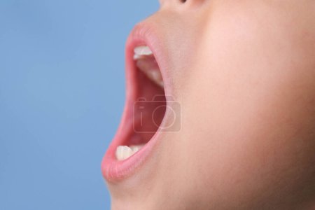 Vue latérale rapprochée de l'intérieur de la cavité buccale d'un enfant en bonne santé avec de belles rangées de dents. Jeune fille ouvre la bouche révélant dents supérieures et inférieures, bilan de santé dentaire et buccodentaire.