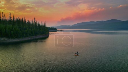 Aerial view of two paddleboarders on Hungry Horse Reservoir at sunset.