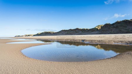 Téléchargez les photos : Une chaîne de piscines marémotrices vues sur la plage de Formby reflétant les dunes de sable qui bordent la majeure partie du littoral de Sefton entre Liverpool et Southport. - en image libre de droit