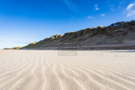 Téléchargez les photos : Motifs ondulés naturels observés au premier plan d'un paysage marin Formby avec des dunes de sable imposantes tapissant l'arrière-plan. - en image libre de droit