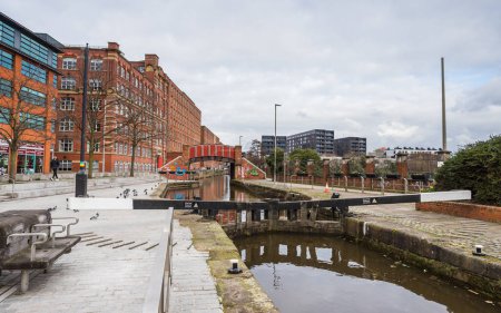 Téléchargez les photos : Rochdale Canal lock 82 seen in front of the pretty red bridge at Ancoats in Manchester pictured in February 2023. - en image libre de droit