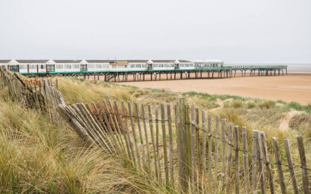 Téléchargez les photos : La jetée peinte en vert et blanc à St Annes-on-the-Sea dans le Lancashire vue sautant sur la plage vide sur la côte de Flyde en mai 2023. - en image libre de droit