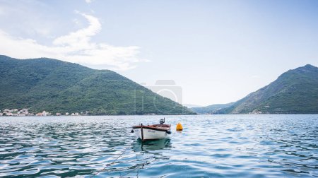Foto de Un barco solitario en la bahía de Kotor amarrado a la orilla de Perast, Montenegro visto en mayo de 2023. - Imagen libre de derechos