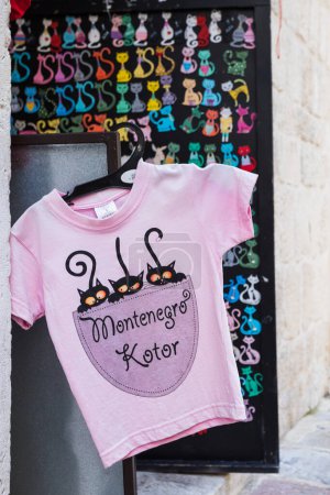 Foto de Una camiseta de gato rosa representada fuera de una tienda en Kotor, Montenegro, en mayo de 2023. La ciudad es famosa por sus gatos callejeros. - Imagen libre de derechos
