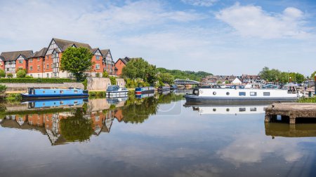 A multi image HDR panorama capture of colourful narrow boats captured reflecting in the water at Northwich Quay on the River Weaver in June 2023 under a bright sky.