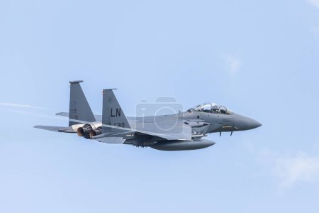 Photo for An F-15E Strike Eagle seen with vapour trails from its wing tips as it takes off from its USAF air base at RAF Lakenheath in Suffolk pictured in August 2023. - Royalty Free Image