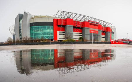 Téléchargez les photos : Un panorama multi-images du stade Old Trafford, domicile du Manchester United Football Club reflétant dans une grande flaque d'eau le 2 janvier 2024. - en image libre de droit