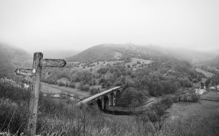La niebla y la baja nube se elevan lentamente desde el Puente de la Cabeza del Monsal, representado por encima del sendero del Monsal en marzo de 2024.