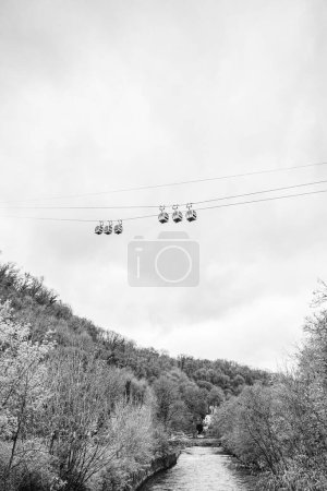 Six cable car cabins pass one another above the River Derwent in Matlock Bath, Derbyshire seen in April 2024