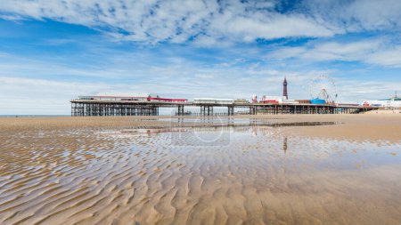 Central Pier spiegelt sich in einem Gezeitenpool am Strand von Blackpool, Lancashire, gesehen am 5. Mai 2024.