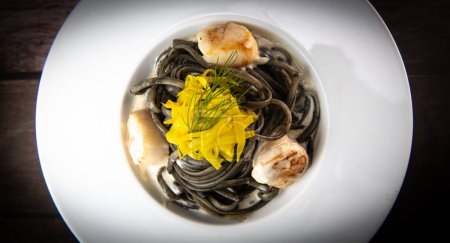 Foto de Receta de Pasta Linguina con tinta de calamar y vieiras, remolacha chioggia amarilla. Foto de alta calidad - Imagen libre de derechos