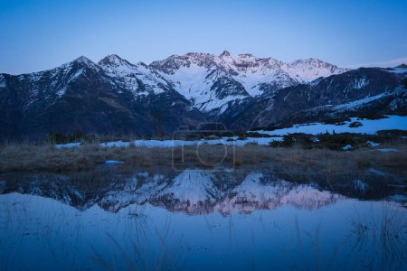 Sunset over the Pyrenees mountains with the reflection of the peaks in the water of the lake High quality 4k footage