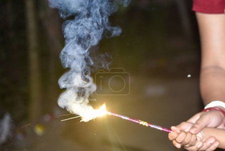 Photo for Burning Sparkler during Indian festival of Light Diwali which causes air pollution - Royalty Free Image