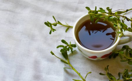 Herbal healing tea from Brahmi or Bacopa monnieri on a white background. A high angle shot with Selective focus on tea and cup.