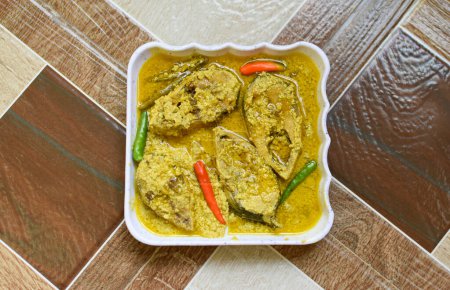 Photo for Sorshe Illish or Hilsa fish cooking with mustard seed, green chili, and poppy seeds. Famous Bengali food. Selective focus. - Royalty Free Image