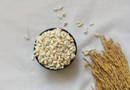 Popped Rice oder Nel Pori auch als Puffed Lahi oder Karthigai Pori in Holzschüssel auf weißem Hintergrund bekannt. Kalorienarme Ernährung Ernährungskonzept. Selektiver Fokus auf Schüssel und Essen.