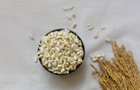 Popped Rice oder Nel Pori auch als Puffed Lahi oder Karthigai Pori in Holzschüssel auf weißem Hintergrund bekannt. Kalorienarme Ernährung Ernährungskonzept. Selektiver Fokus auf Schüssel und Essen.
