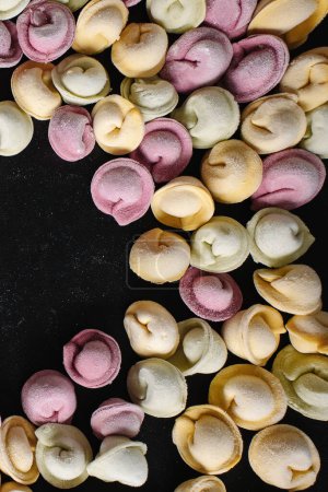 Foto de Dumplings hechos a mano multicolores de los niños primer plano con espacio para el logotipo o el texto sobre fondo negro. - Imagen libre de derechos