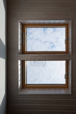 Photo for Mansard windows in a modern interior. White siding and blue sky in a cozy home. - Royalty Free Image
