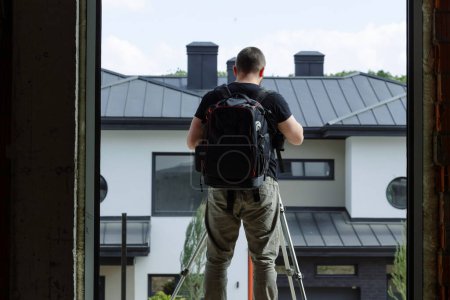 Photo for An interior photographer on a construction site takes a photo from a tripod for the website. - Royalty Free Image