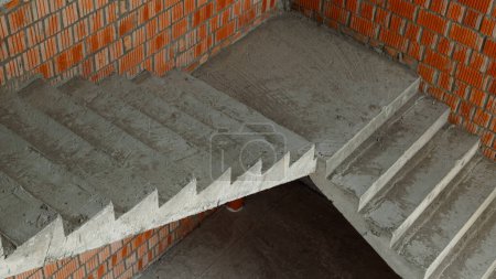 Photo for Concrete stairs in a new building near a brick wall. Start of construction. - Royalty Free Image
