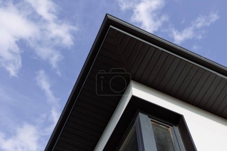 Photo for The dark slope of the roof of the house on the background of the sky. - Royalty Free Image